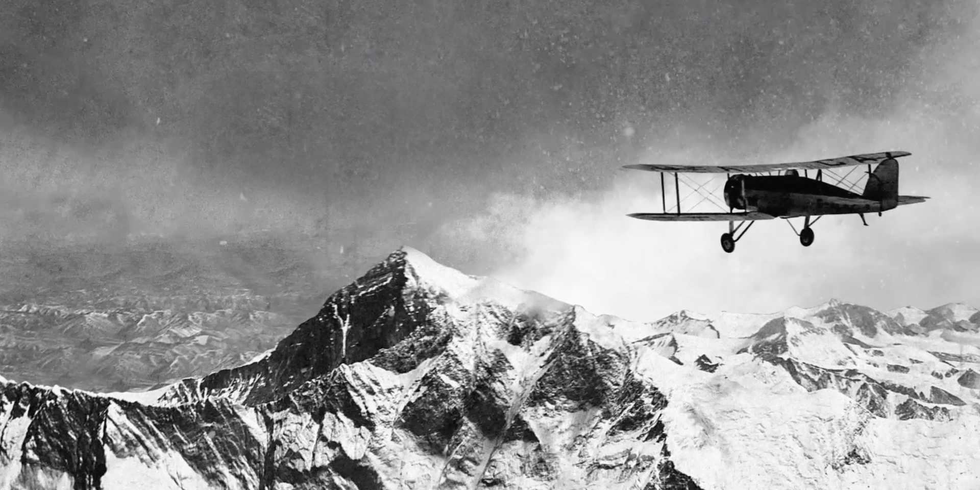 Airplane soaring above mountain peak