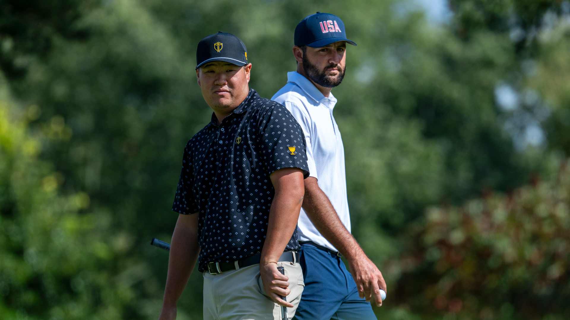 Two golfers standing on a golf course during a team competition.
