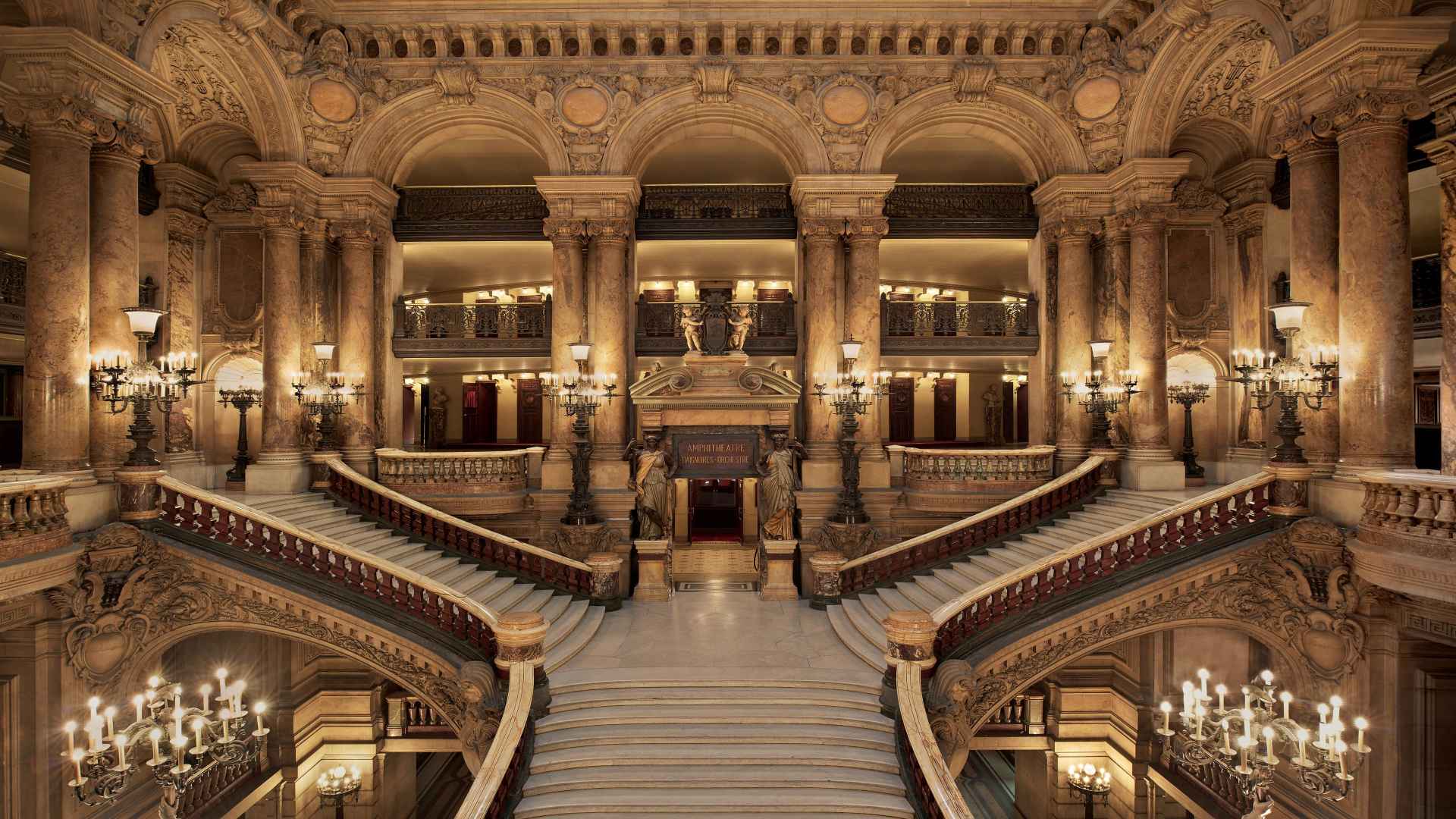 The grand marble staircase and ornate interior architecture of the Palais Garnier opera house in Paris   
